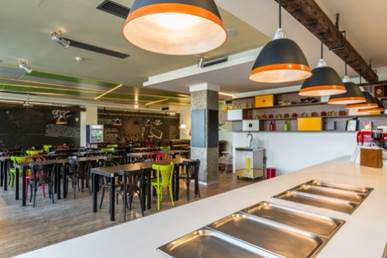 Interior of a restaurant showing serving dishes and table seating.