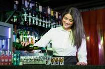 A bartender pouring shots at the bar.