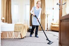 Housekeeping staff member cleaning a hotel room.