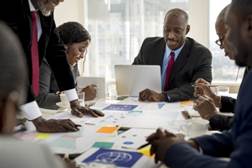 A group of people sitting a meeting.